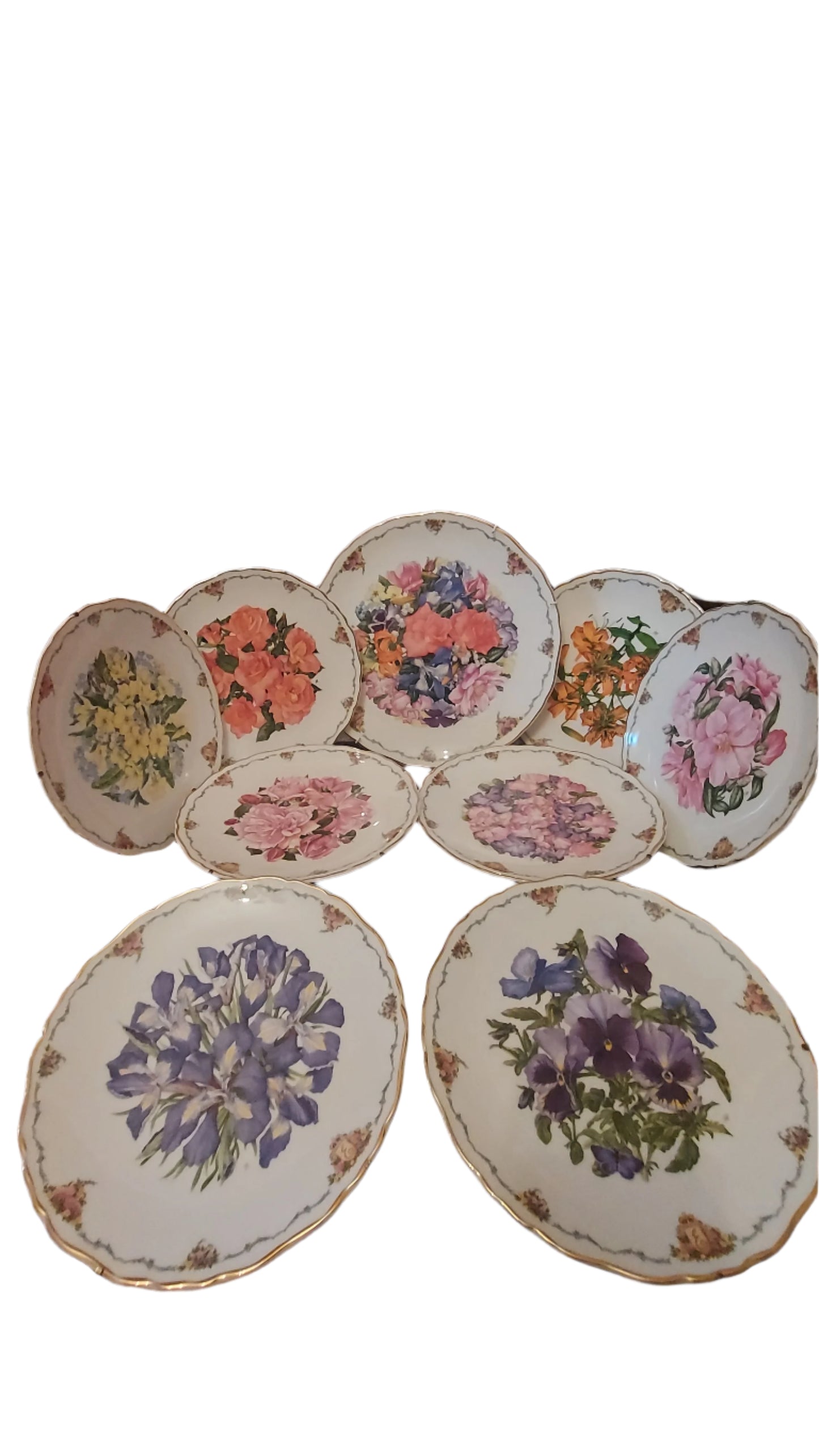 Decorative collectible porcelain plates from Royal Albert, part of "The Queen Mother's Favorite Flowers" series.