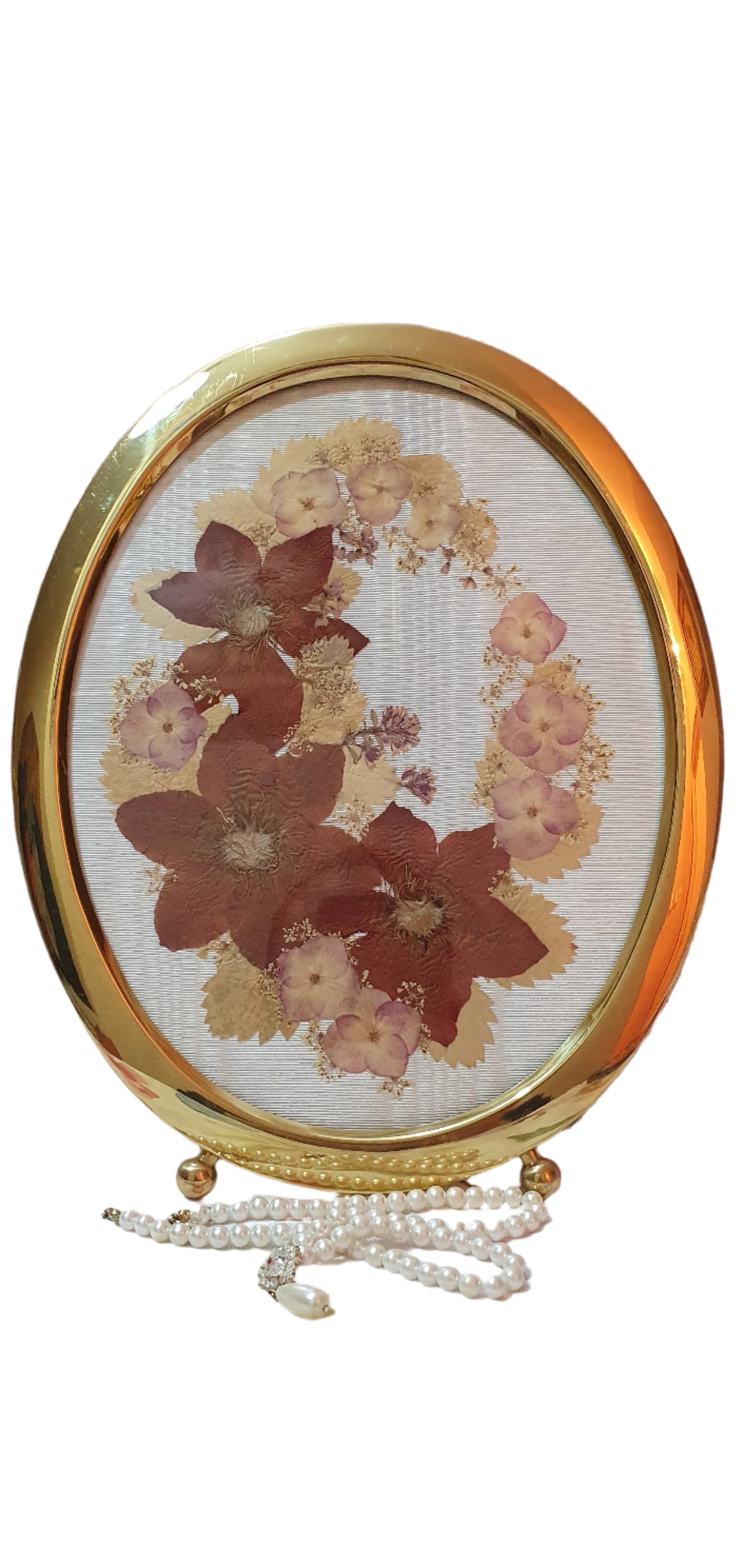 Brass oval frame with arrangement of dried pressed flowers